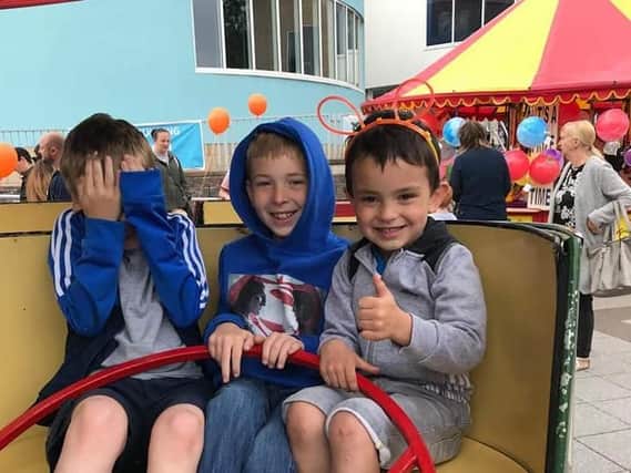 Three friends enjoy a fairground ride at the Burnley Campus 10th anniversary fun day.