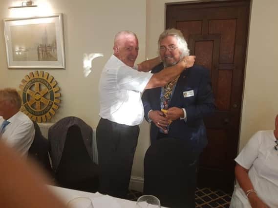 Dave Alexander  hands over his chain of office to Alan Ravenscroft who takes over from him as president of Padiham Rotary Club.