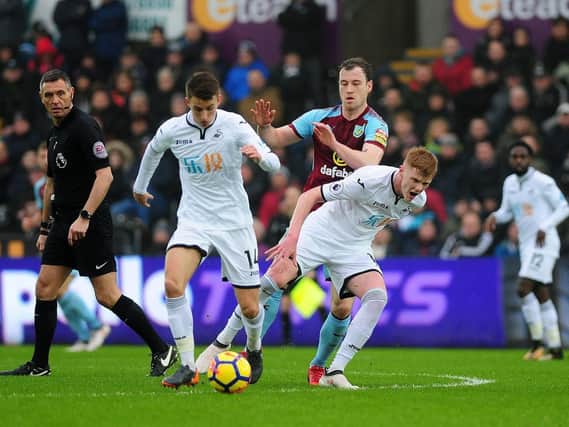 Sam Clucas and Clarets striker Ashley Barnes battle it out for the ball