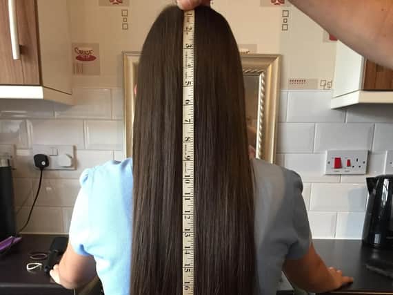 The 11-year-old's hair fell to the bottom of her back before she had 18 inches lobbed off. (s)