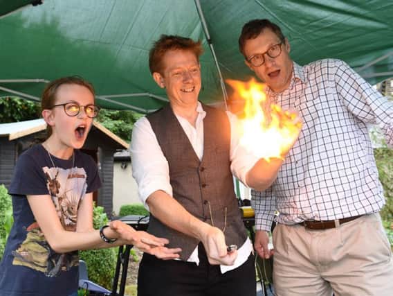 The Rev. Andy Gray from Clitheroe (centre) entertains Bishop Philip and Lydia Cooke from Lancaster during his fiery magic routine