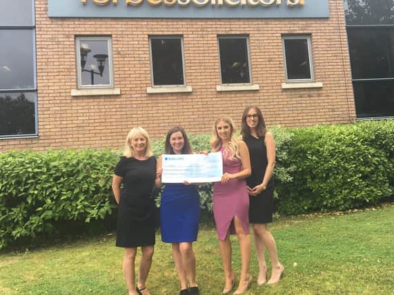Sharon Froggatt and Natalie Bohane from CARES receive a cheque for 428 from Abigail Mottram and Rebecca McCann from Forbes.
