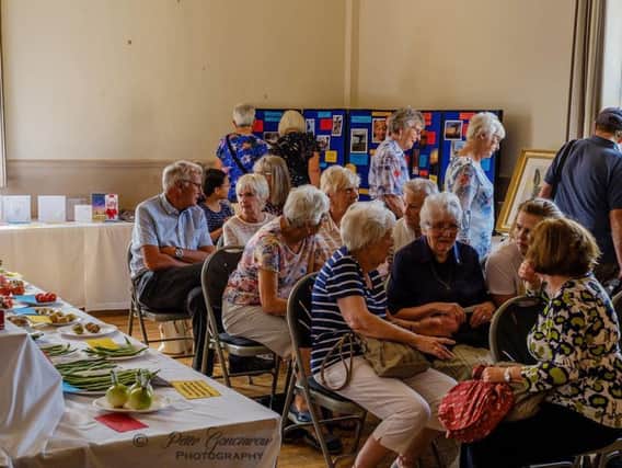 Visitors to the 60th annual Cliviger Flower and Handicrafts Show gather to hear the results.