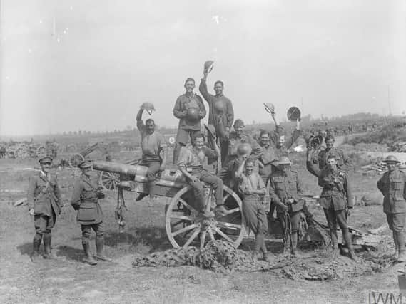Following the capture of Grevillers by the New Zealand Division, Men of the Royal Garrison Artillery pose beside one of the 4.2 inch guns of a captured battery at Grevillers, 25 August 1918. Note the camouflage netting on the ground, which was designed to prevent the guns from being spotted from the air.  IWM (Q 11243)