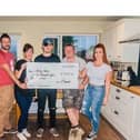 Josh (centre) receives a cheque from his cousins, Charlotte and Luke Simpson (right) and their friends and colleagues Adam Wallwork (left) and Amanda Kelly who took part in a hike  with them to help raise the cash.