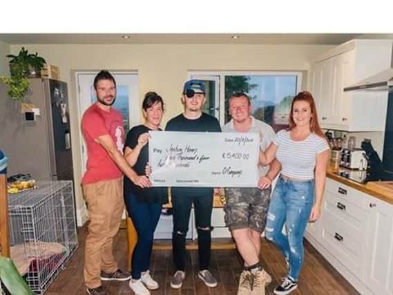 Josh (centre) receives a cheque from his cousins, Charlotte and Luke Simpson (right) and their friends and colleagues Adam Wallwork (left) and Amanda Kelly who took part in a hike  with them to help raise the cash.