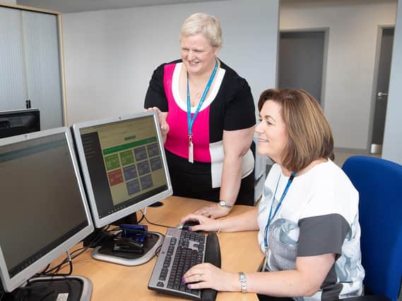 Sue Elliston, Directorate Manager of Centralised Outpatients and Administration Services (standing) with Elaine Eyre (Booking Centre Manager)