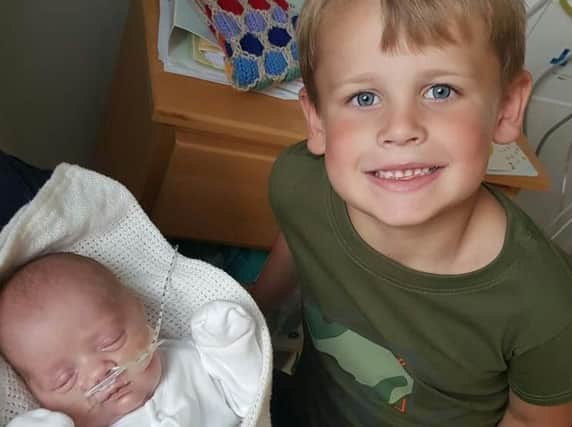 Baby Max Hughes, who was born at 26 weeks, with his proud big brother Ryan (seven).