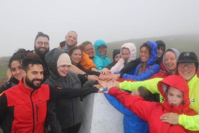 Katy Sullivan and supporters celebrate her achievement at the top of Pendle Hill on Sunday.