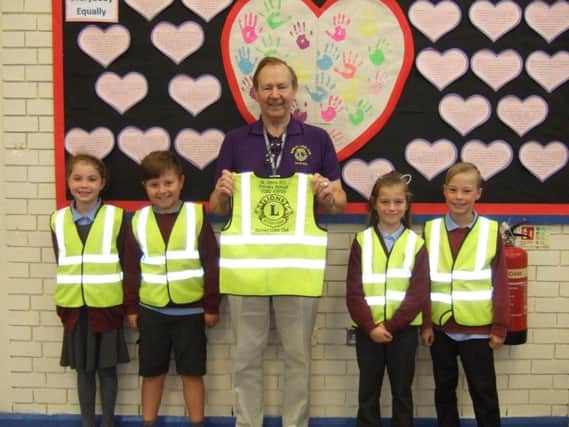 Burnley Lions president Frank Seed presents the hi-vis vests to pupils at St John's RC Primary School, Burnley.