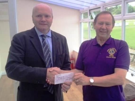 Burnley Boys and Girls Club Chairman, Peter Maddock, receiving a cheque for their memorial garden.