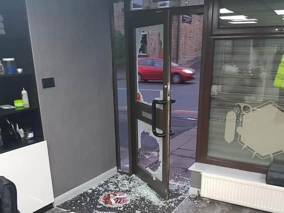 The smashed glass panel in the door at the Park Lane Hair Studio which raiders targeted this week before making off with around 300 in charity cash.