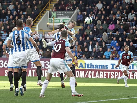 Burnley's Sam Vokes scores the opening goal despite the attentions of Huddersfield Town's Christopher Schindler