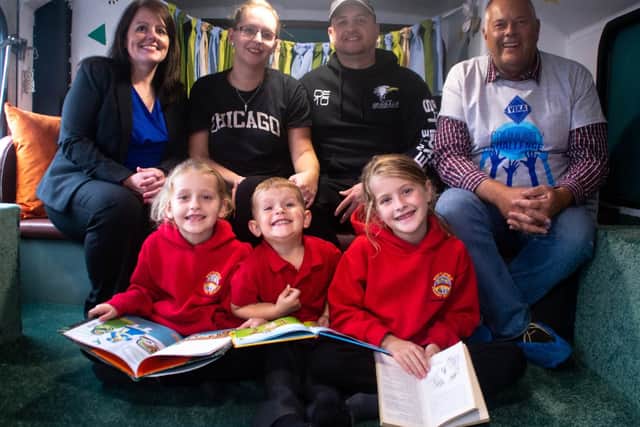 All aboard the official opening of the Whittlefield Primary School Woodland Library Bus are (from left to right) headteacher Mrs Helen Kershaw, Lauren and Carl Everitt  and their children, Madison, Ruby and Charlie and Dave Jones, managing director of VEKA.