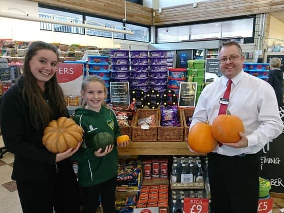 Shawn Dixon, store manager, Emily Nash, customer assistant, and Charlotte, a regular customer to the store.