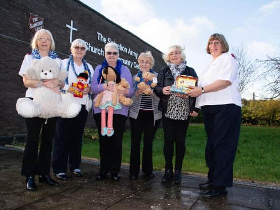 Captain Maisie Veacock (right) hands over gifts to Burnley Express reporter Sue Plunkett watched by Salvation Army volunteers.