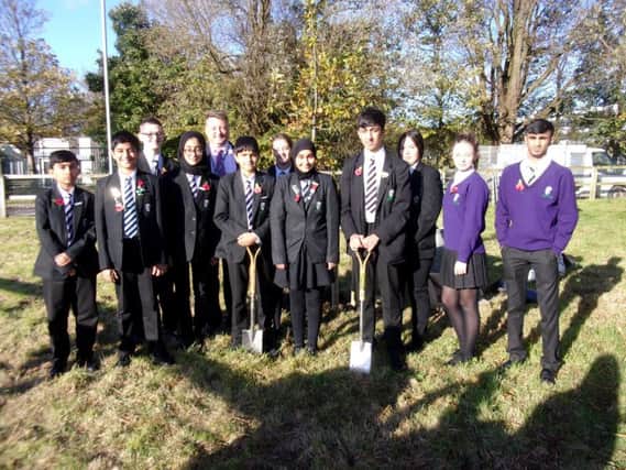 Sir John Thursby students prepare to plant the oak tree as part of the commemorations to mark the 100th anniversary since the end of World War One.