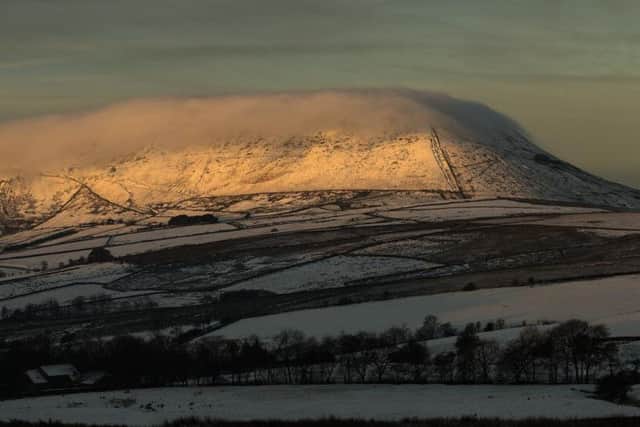 Snow-covered Pendle shrouded in mist