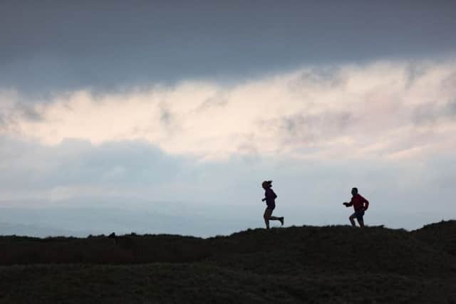 Runners Kerrie-Anne Bretherton and Mick Dobson on a Pendle skyline