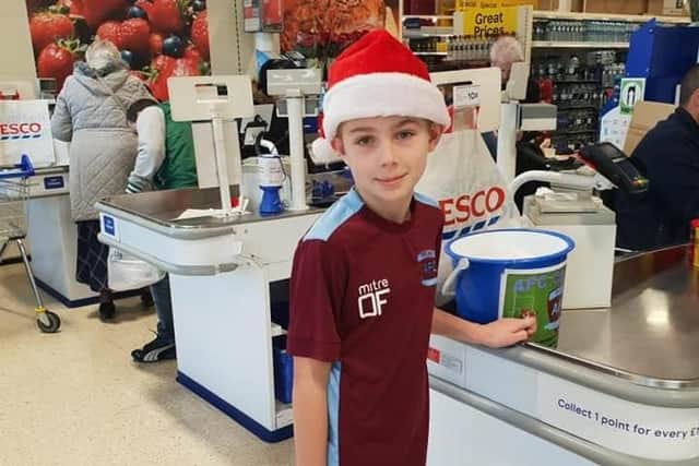An AFC Clarets player gets ready to help shoppers pack their bags.