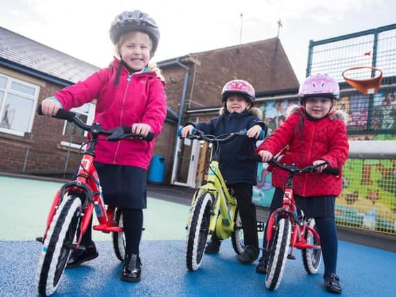 These three classmates at St Augustine's Primary School in Burnley are enjoying learning how to ride a bike.