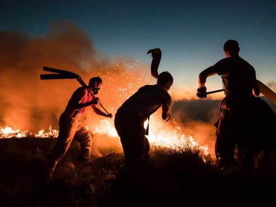Firefighters tackling a wildfire on Winter Hill near Bolton. The huge fires that ravaged moorland near Greater Manchester this summer likely had a "shocking" impact on air quality, according to new analysis.