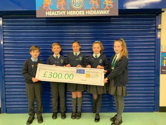 Pupils from St James' Lanehead with the money they raised for Pendleside Hospice