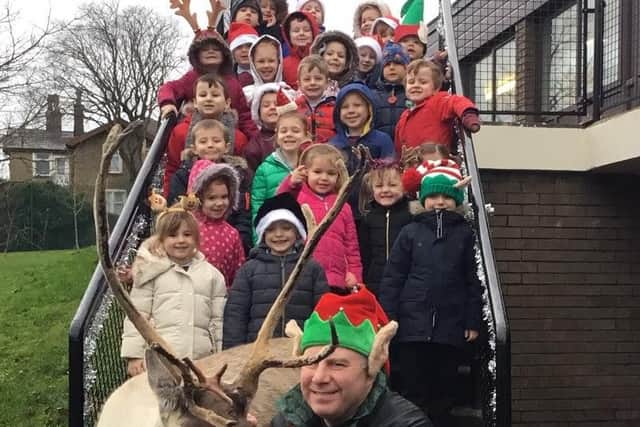 Reception class children meet the reindeer and the elf at Holy Trinity Primary School in Burnley.