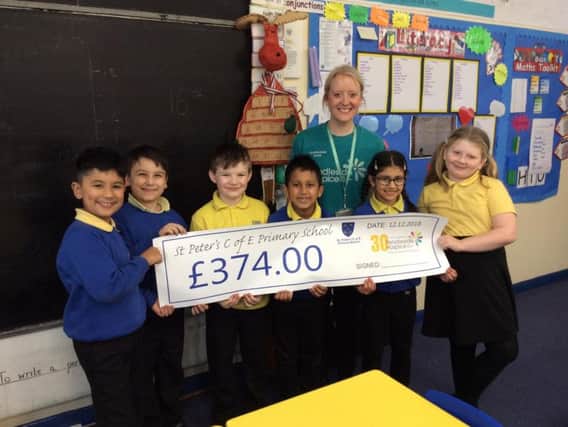 Pupils from St Peter's Primary School with the money they raised for Pendleside Hospice