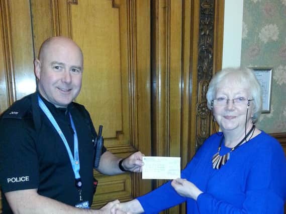 Coun. Ida Carmichael, who is secretary of the Friends of Ightenhill Park, hands  over a cheque for 150 to Sgt Dave Pascoe who received the cheque on behalf of the RAF Benevolent Fund.