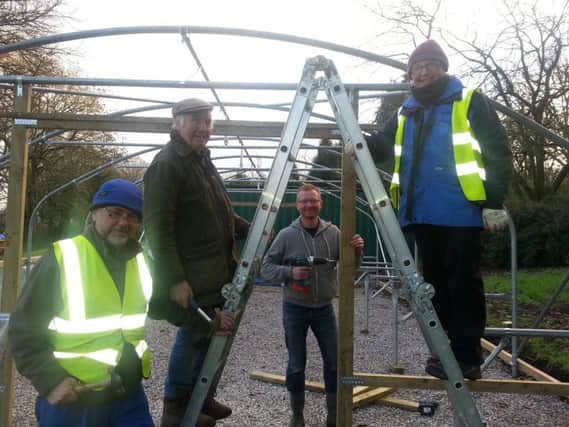 Volunteers from the Friends of Ightenhill Park group at work on the polytunnels to protect their plants and vegetables.