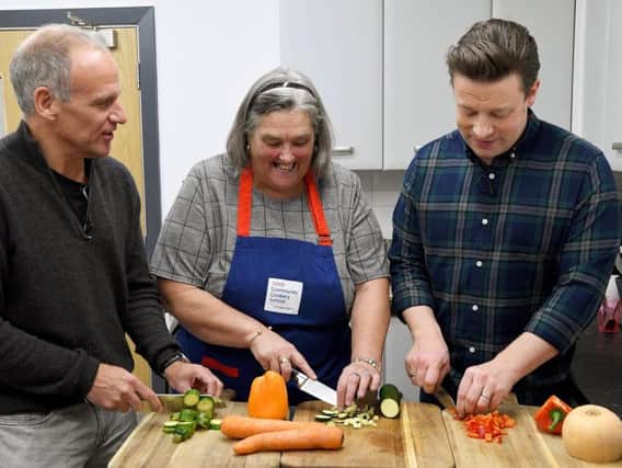 Jamie Oliver at work with two of the chefs at the Tesco Community Cookery School.