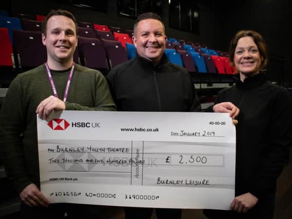 Aiden Kelly (left) who is finance and operations co-ordinator at Burnley Youth Theatre receives the cheque from Mark Dempsey who is Hospitality General Manager for Burnley Leisure and Krista Humphreys who is the assistant hospitality manager.