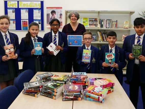Librarian Mrs Halstead with pupils at Blessed Trinity RC College and some of the books they won in the James Patterson Big Book giveaway competition.
