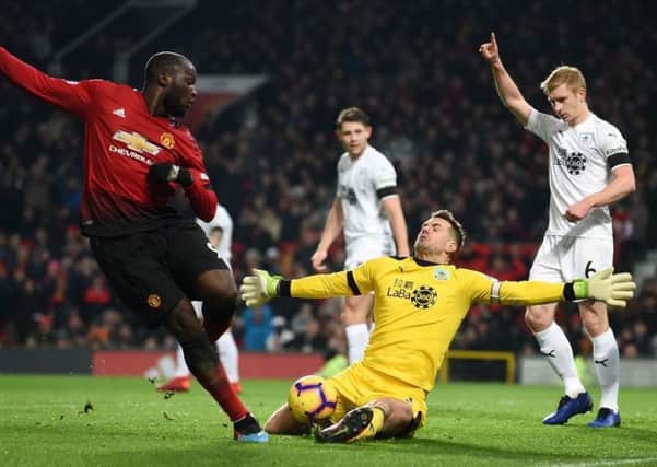 Burnley's English goalkeeper Tom Heaton (C) saves a shot from Manchester United's Belgian striker Romelu Lukaku (L) during the English Premier League football match between Manchester United and Burnley at Old Trafford in Manchester, north west England, on January 29, 2019. (Photo by Paul ELLIS / AFP) / RESTRICTED TO EDITORIAL USE. No use with unauthorized audio, video, data, fixture lists, club/league logos or 'live' services. Online in-match use limited to 120 images. An additional 40 images may be used in extra time. No video emulation. Social media in-match use limited to 120 images. An additional 40 images may be used in extra time. No use in betting publications, games or single club/league/player publications. /         (Photo credit should read PAUL ELLIS/AFP/Getty Images)