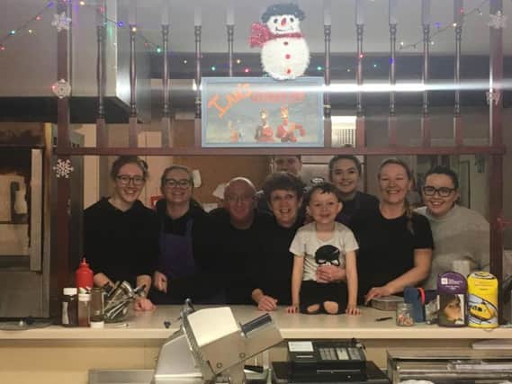 Ian and Sandra Roberts are pictured third and fourth from the left with staff at the Chicken Deli.