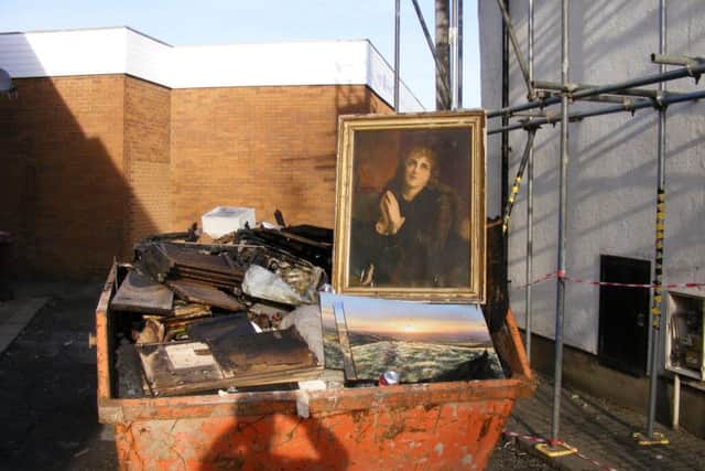 In this poignant image, paintings destroyed in the blaze have been placed in a skip.