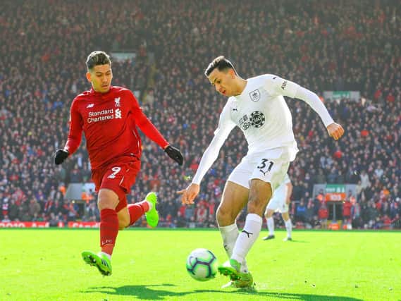 Burnley's Dwight McNeil takes on Liverpool's Roberto Firmino at Anfield