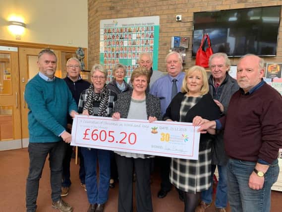 Friends and relatives of Tony Cummings present a cheque to Pendleside Hospice after a concert was held in his memory.