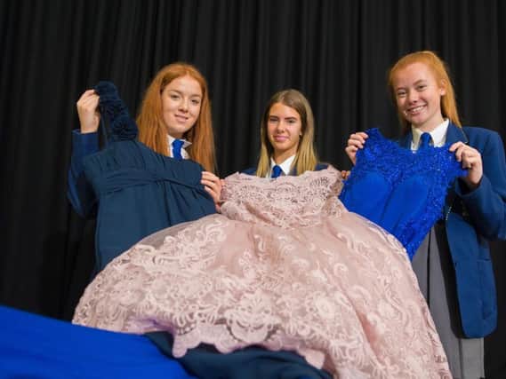 Holly Keogh, Grace Harker and Katie Dilworth with some of the dresses donated to the pop up shop at Blessed Trinity RC College in Burnley.