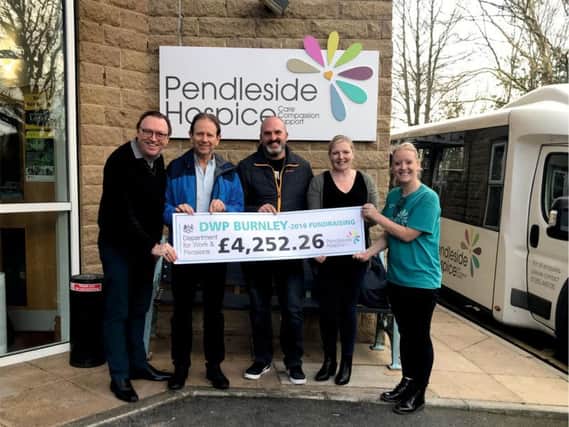 Andrew Gibbons, Steve Neary, Darren Moss and Melanie Crook from DWP Burnley present their cheque to hospice fund-raiser Leah Hutchinson