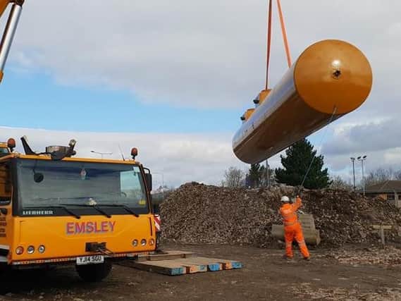 A crane hoists one of the fuel tanks onto the site at Gannow Top where a petrol station, Spar shop and Starbucks Coffee will open in the summer.