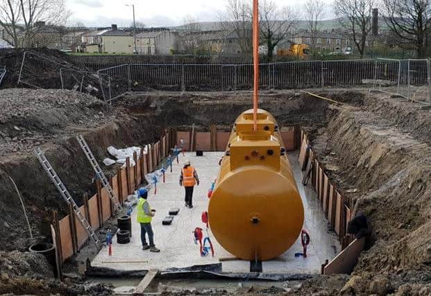 Workmen prepare to examine the fuel tank which is now in place in its new home.