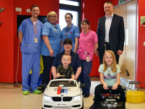 Four-year-old Tobiasz Wusiewicz from Burnley became the first child to test drive the Bowker BMW baby racer, watched by (from left) Dr Ian Clegg, Staff Nurses Gillian Brand and Charlotte Caffrey, Play Leader Angela Ashton, Bowker BMW Managing Director Chris Eccles and (front) Sister Rita Ogden