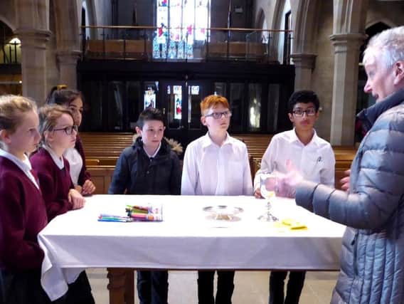 Pupils from St Leonard's Primary School in Padiham listen intently as a volunteer explains about the Eucharist at St Leonard's Church.