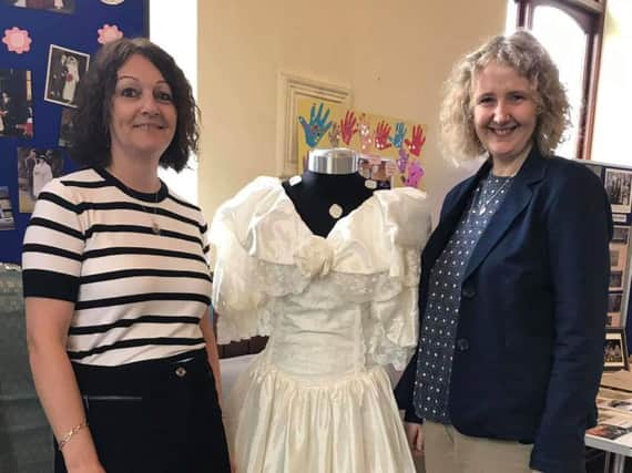 Mount Zion Church treasurer Helen Keegan with her wedding dress she wore when  when she tied the knot at the church. She is pictured with one of her bridesmaids.