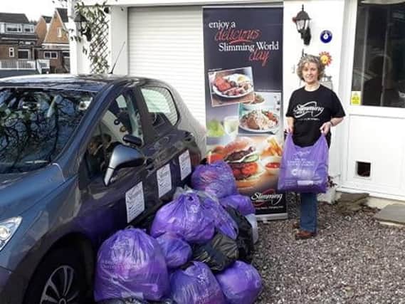 Slimming World consultant Caroline Griffiths with some of the bags of clothes donated by group members in Burnley to the Golden Slimming World Clothes Throw for Cancer Research UK