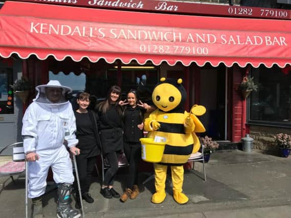 Luke the keeper and Suzanne as the giant bee are pictured with staff outside Kendalls sandwich shop in Padiham.