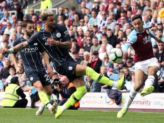Burnley's Dwight McNeil crosses despite the attentions of Manchester City's Kyle Walker