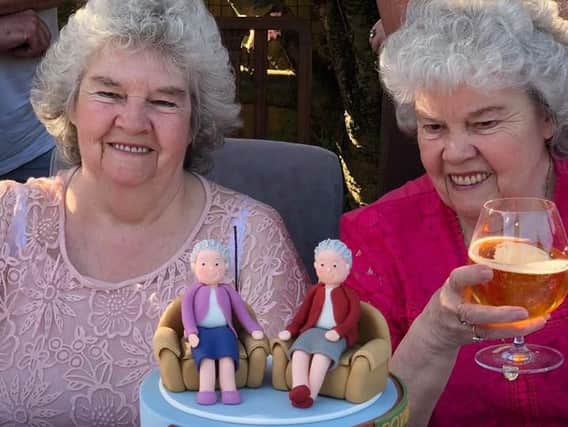 Twins Theresa Clegg andNorah Robinson with their 80th birthday cake.